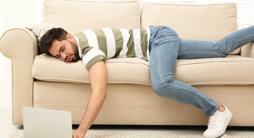 A guy laying on sofa seat with procrastination